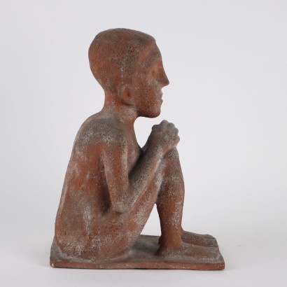 Niño sentado en sacos de pino terracota