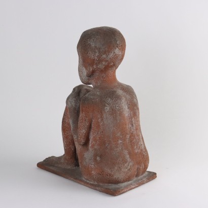 Niño sentado en sacos de pino terracota