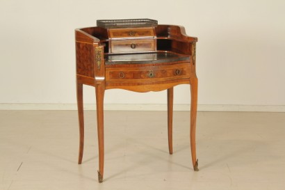 Scrittoio da centro, scrittoio dalla linea mossa.cassetto sotto-piano, piano estraibile, inserto in pelle, vani a giorno, cassettini sagomati con pianetto in marmo. Riserve a marquetterie e fregi.