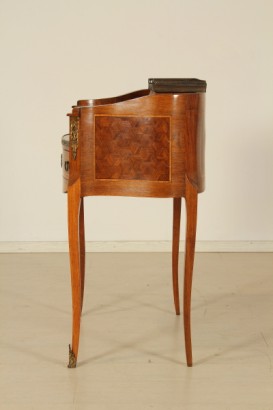 Scrittoio da centro, scrittoio dalla linea mossa.cassetto sotto-piano, piano estraibile, inserto in pelle, vani a giorno, cassettini sagomati con pianetto in marmo. Riserve a marquetterie e fregi.